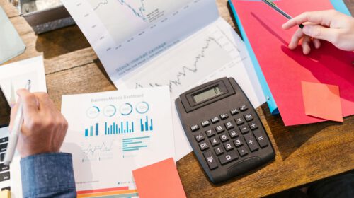 Financial analysis and planning tools with graphs and calculator on a table.